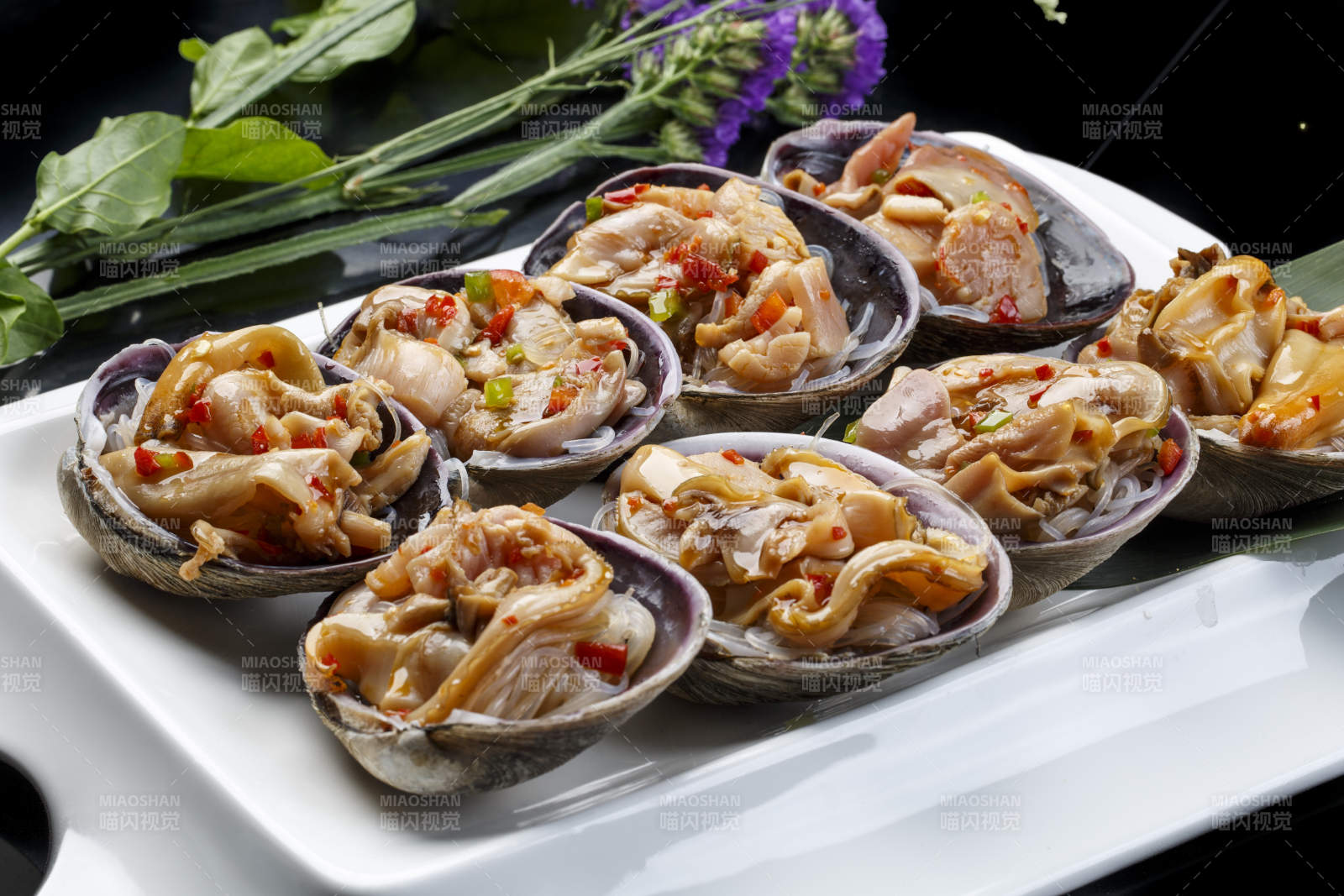鼎形瓷盘装的海鲜炭烤紫石房蛤天鹅蛋图片