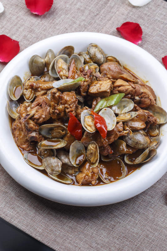 圆形白瓷盘装的花蛤炖鸡块图片