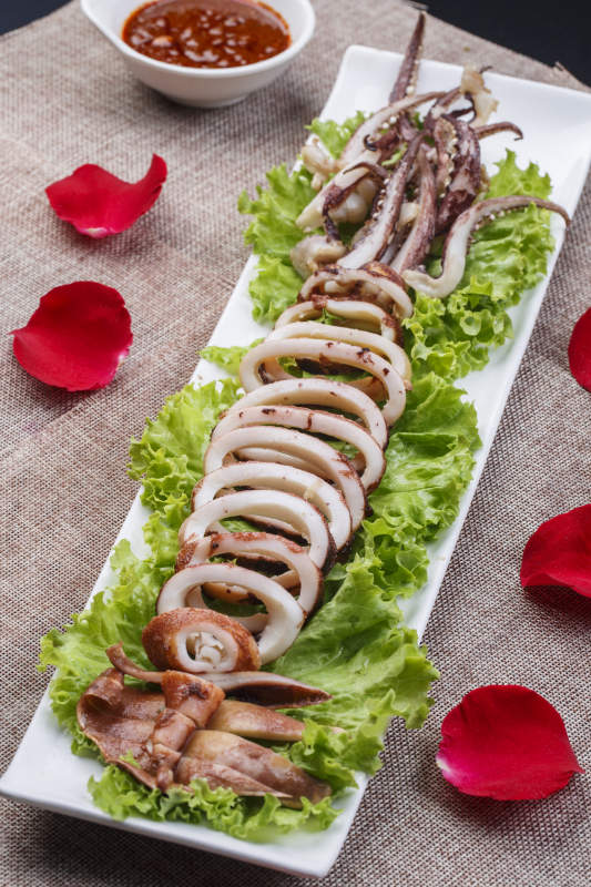 长条白瓷盘装的油煎深海大鱿鱼图片