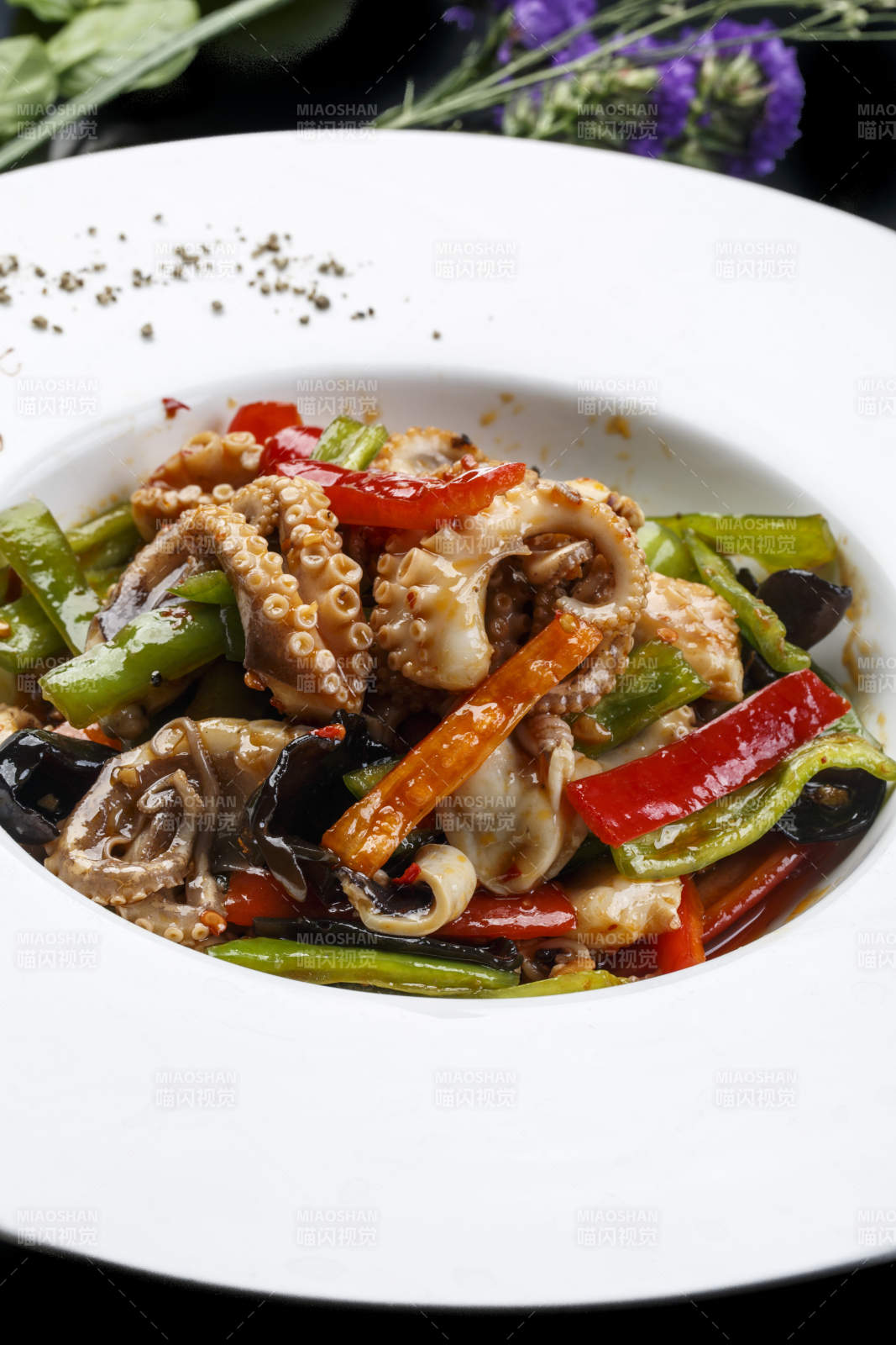 白色圆形瓷盘装的海鲜酱爆八爪鱼图片