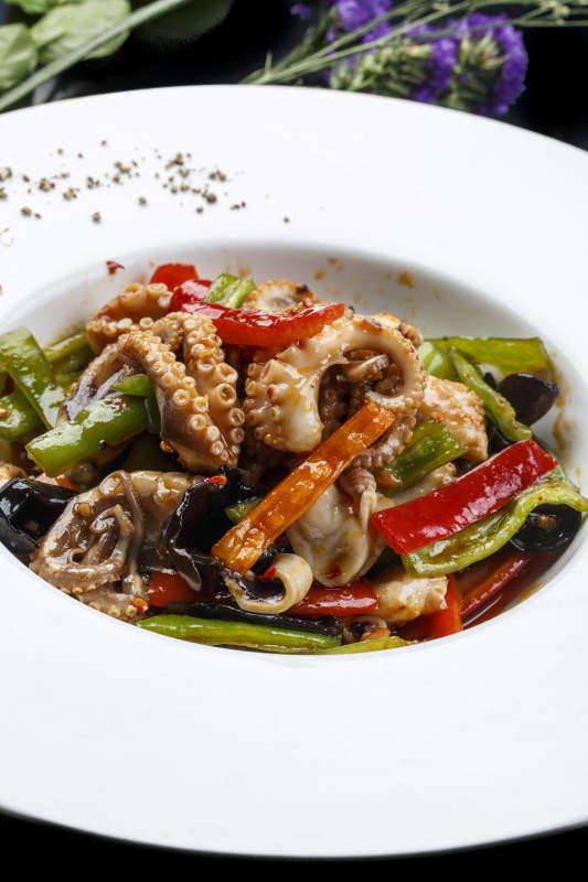 白色圆形瓷盘装的海鲜酱爆八爪鱼图片