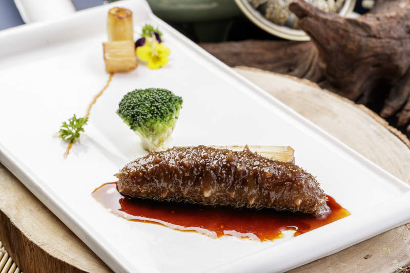 白色瓷盘装的捞汁梅花参图片