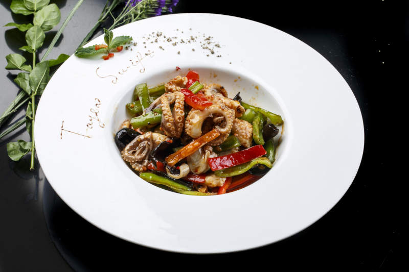 白色圆形瓷盘装的海鲜酱爆八爪鱼图片