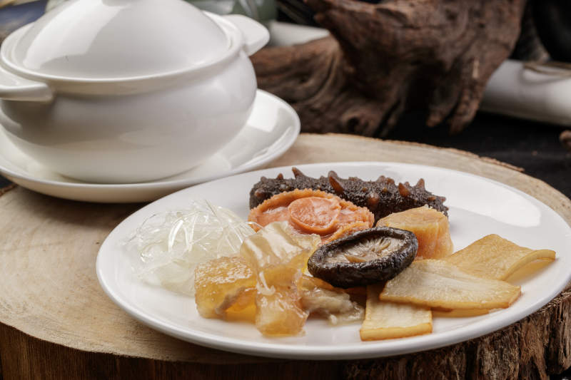 松木菜板上的白瓷餐具撞得浓汤海鲜滋补汤羹图片