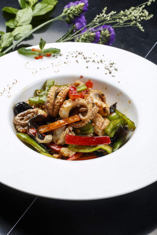 白色圆形瓷盘装的海鲜酱爆八爪鱼图片