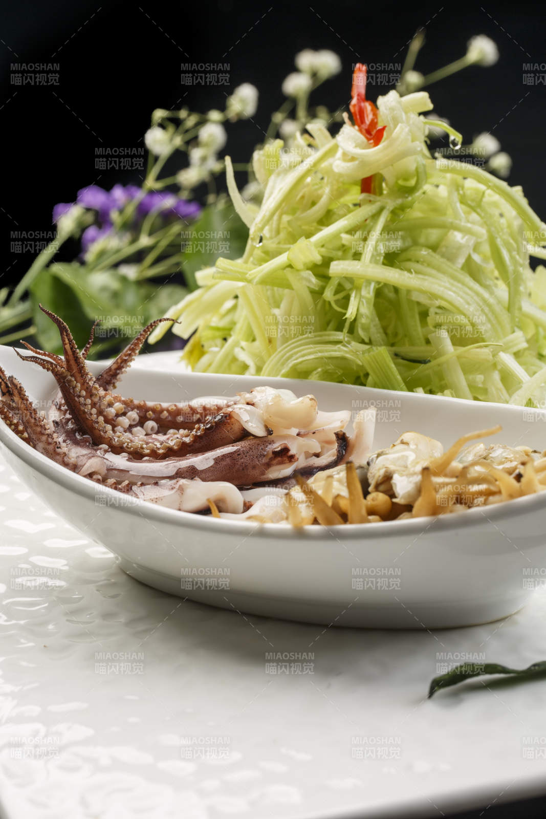 白色方形瓷盘装的西芹拌海鲜图片