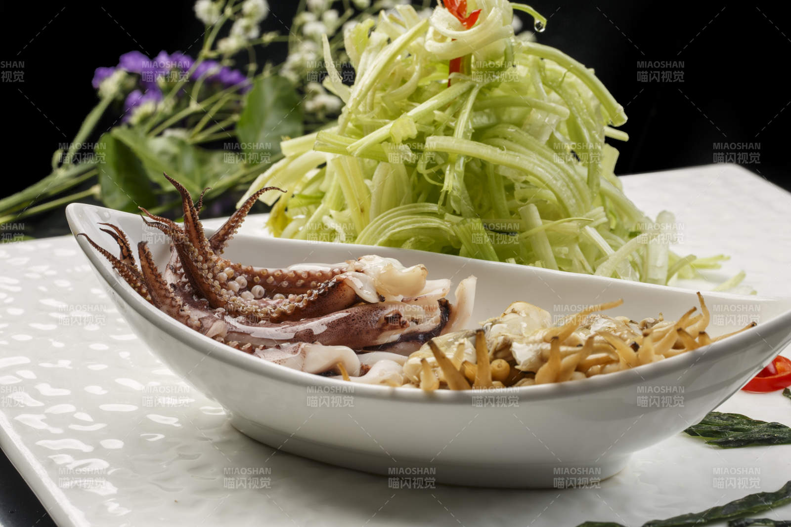 白色方形瓷盘装的西芹拌海鲜图片