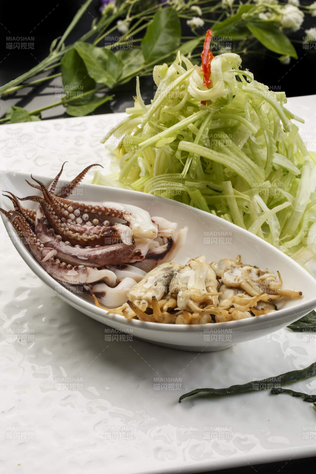 白色方形瓷盘装的西芹拌海鲜图片