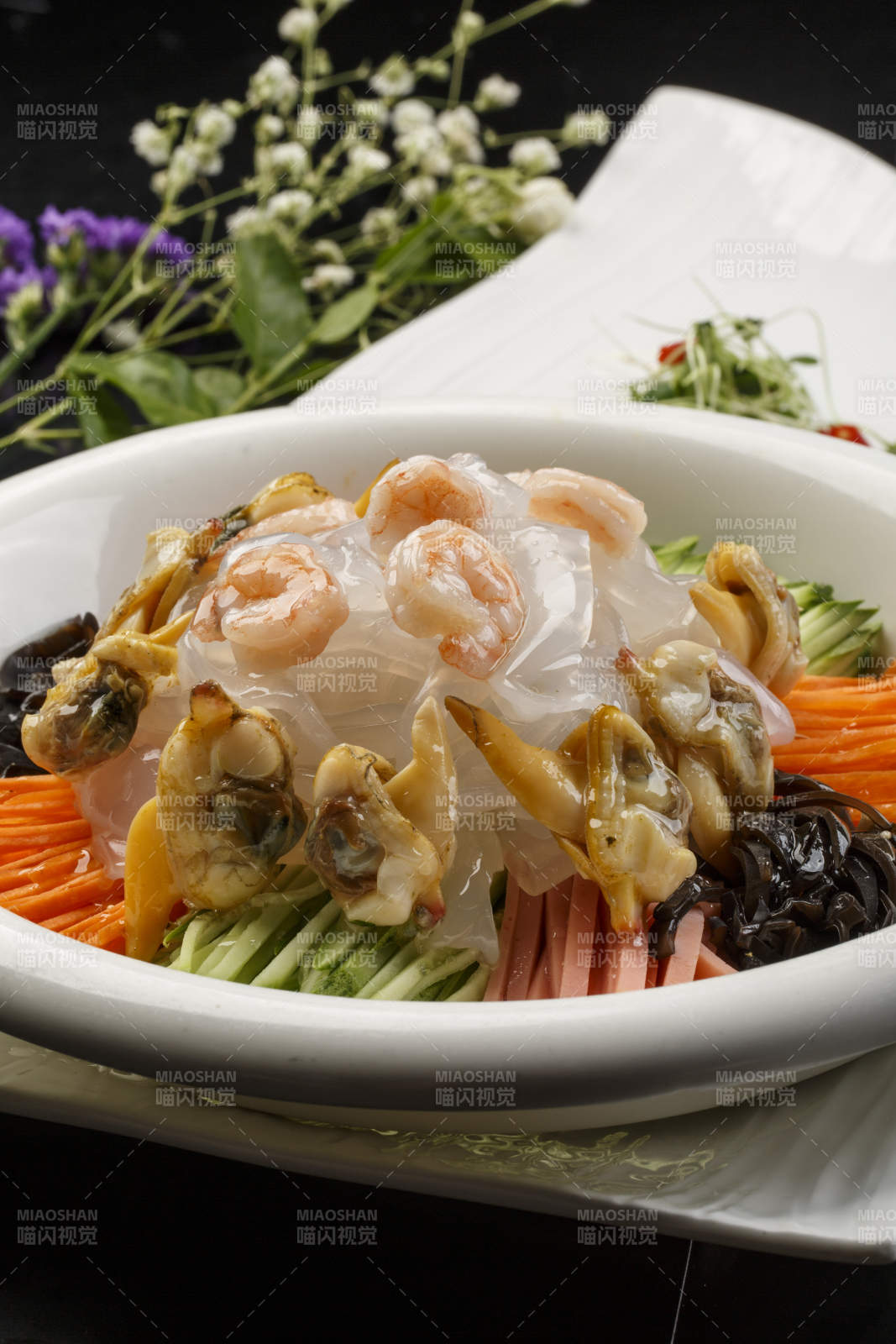 白色圆瓷盘装的海鲜大拉皮图片