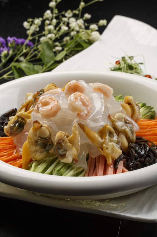 白色圆瓷盘装的海鲜大拉皮图片