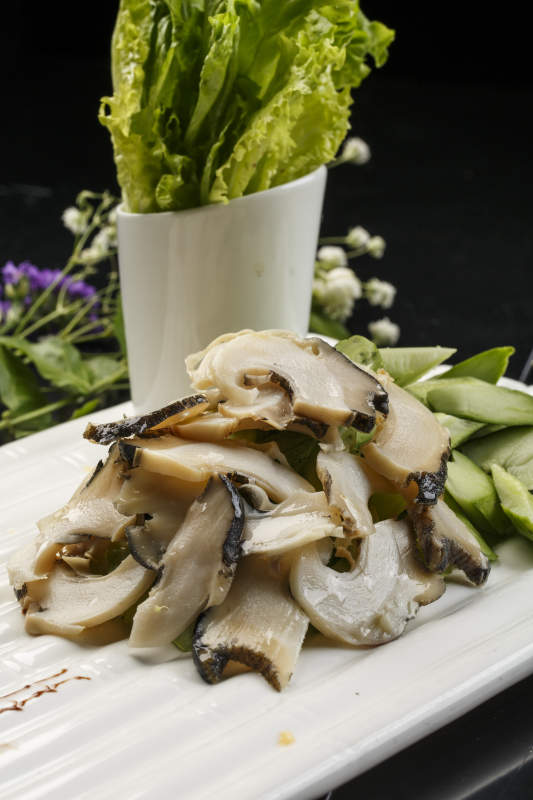 白色瓦楞形瓷盘装的温拌大海螺图片