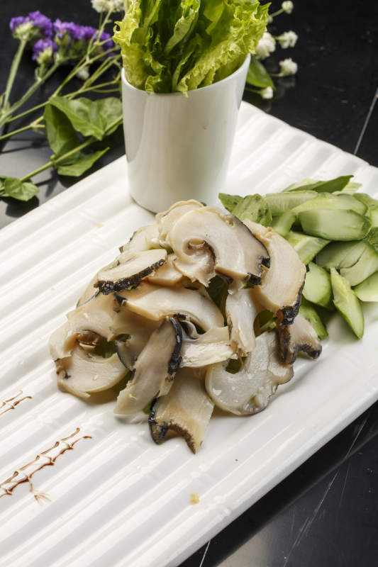 白色瓦楞形瓷盘装的温拌大海螺图片