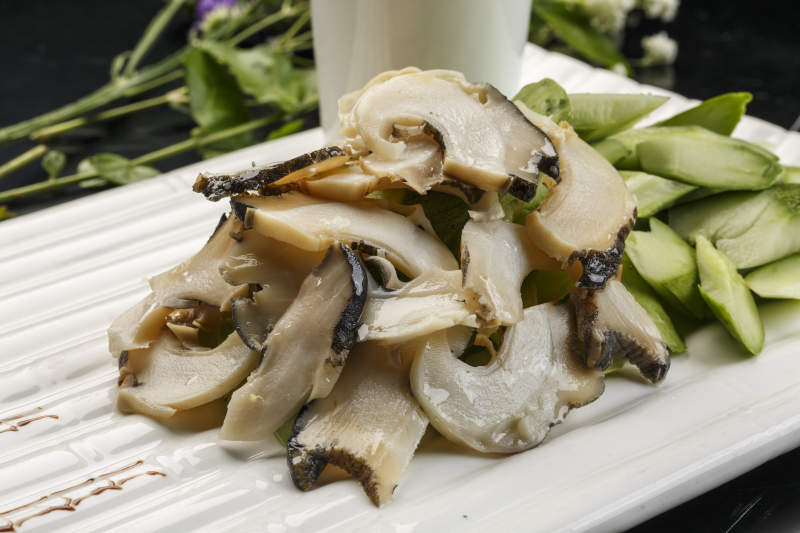 白色瓦楞形瓷盘装的温拌大海螺图片