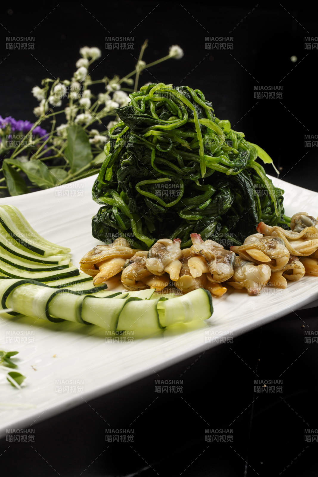 白色长方形瓷盘装的菠菜拌蛤肉图片