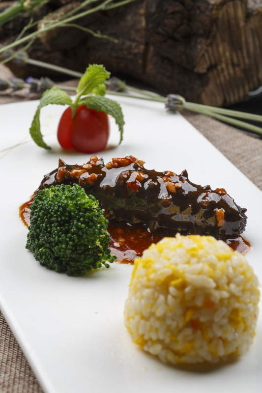 长方形白瓷盘装的肉酱海参捞饭图片