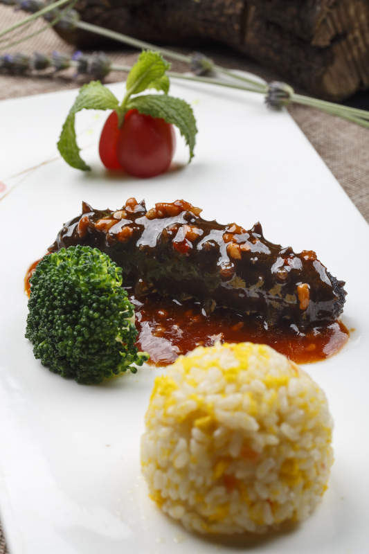 长方形白瓷盘装的肉酱海参捞饭图片