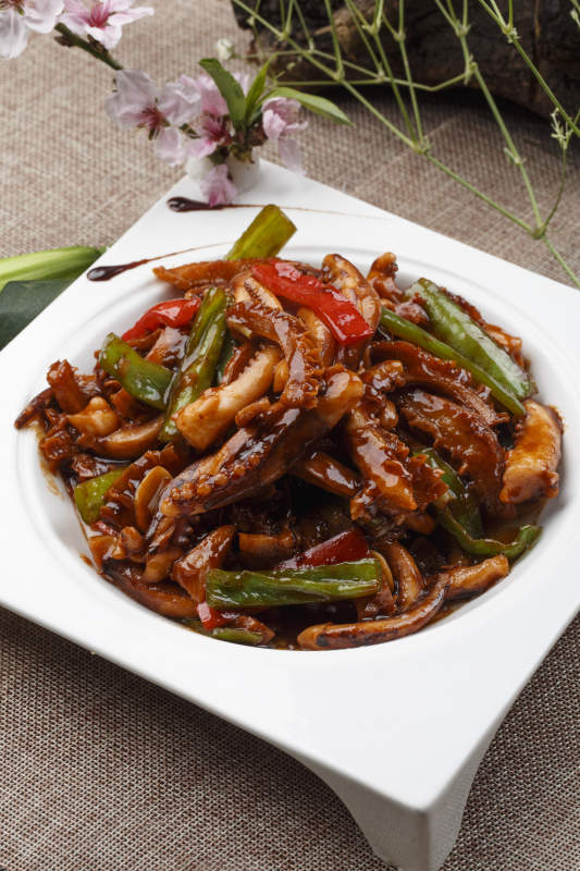 白色瓷盘装的的海鲜香辣酱爆鱿鱼须图片