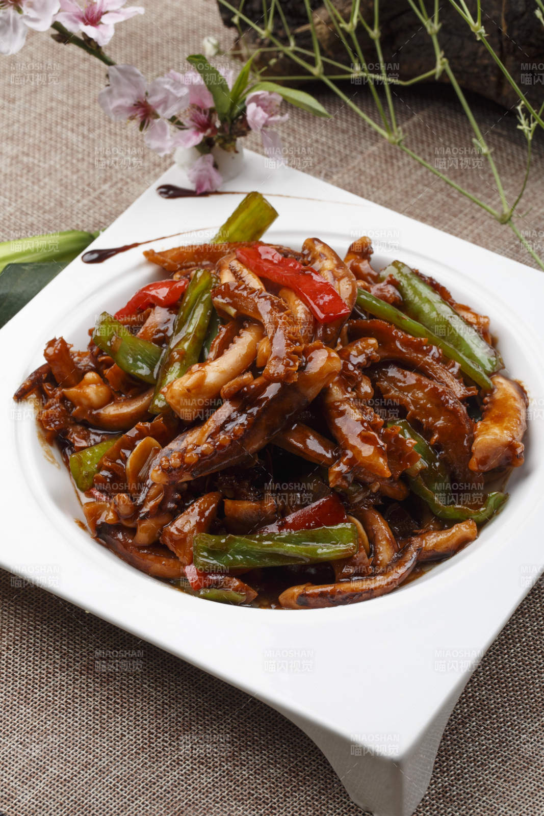 白色瓷盘装的的海鲜香辣酱爆鱿鱼须图片