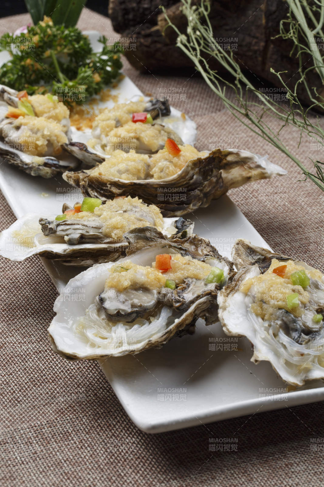 条形白瓷盘装的蒜蓉粉丝蒸生蚝图片
