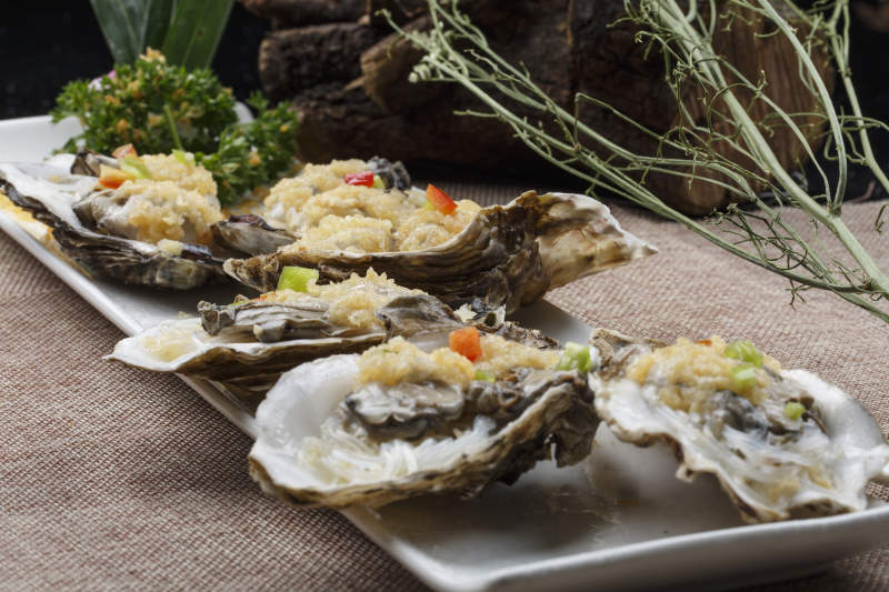 条形白瓷盘装的蒜蓉粉丝蒸生蚝图片