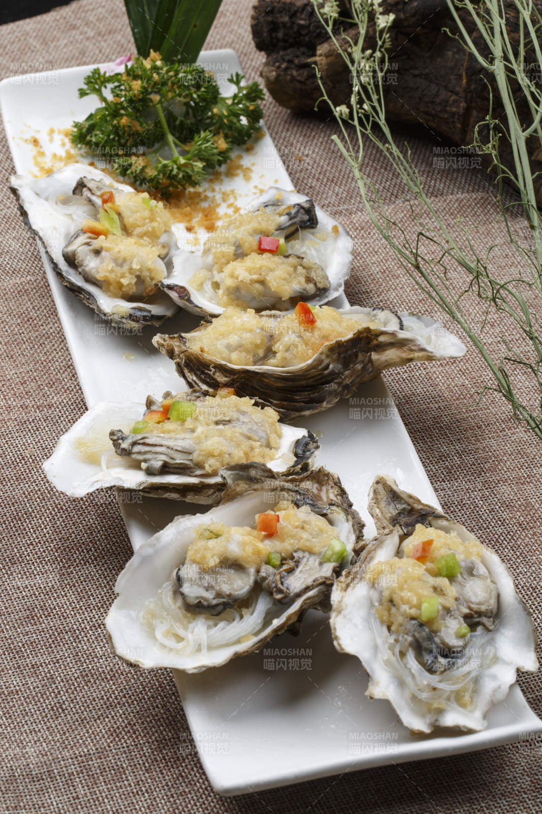 条形白瓷盘装的蒜蓉粉丝蒸生蚝图片