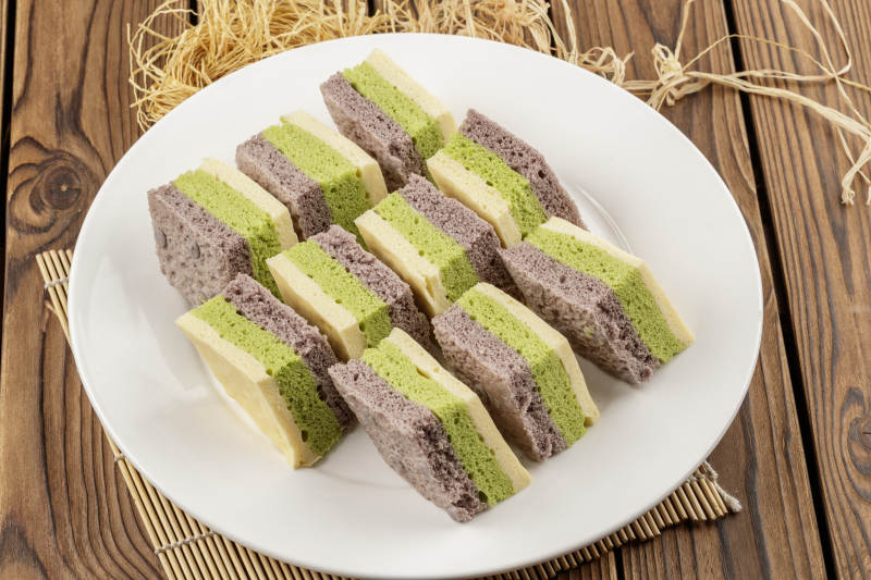 白色圆形磁盘装的三色发糕图片