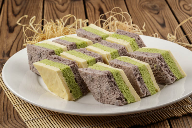 白色圆形磁盘装的三色发糕图片