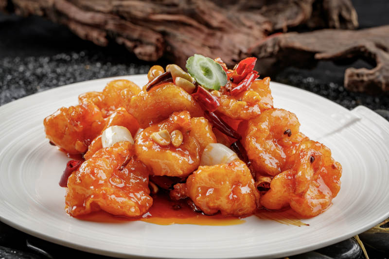 白色圆盘装的宫保大虾球图片