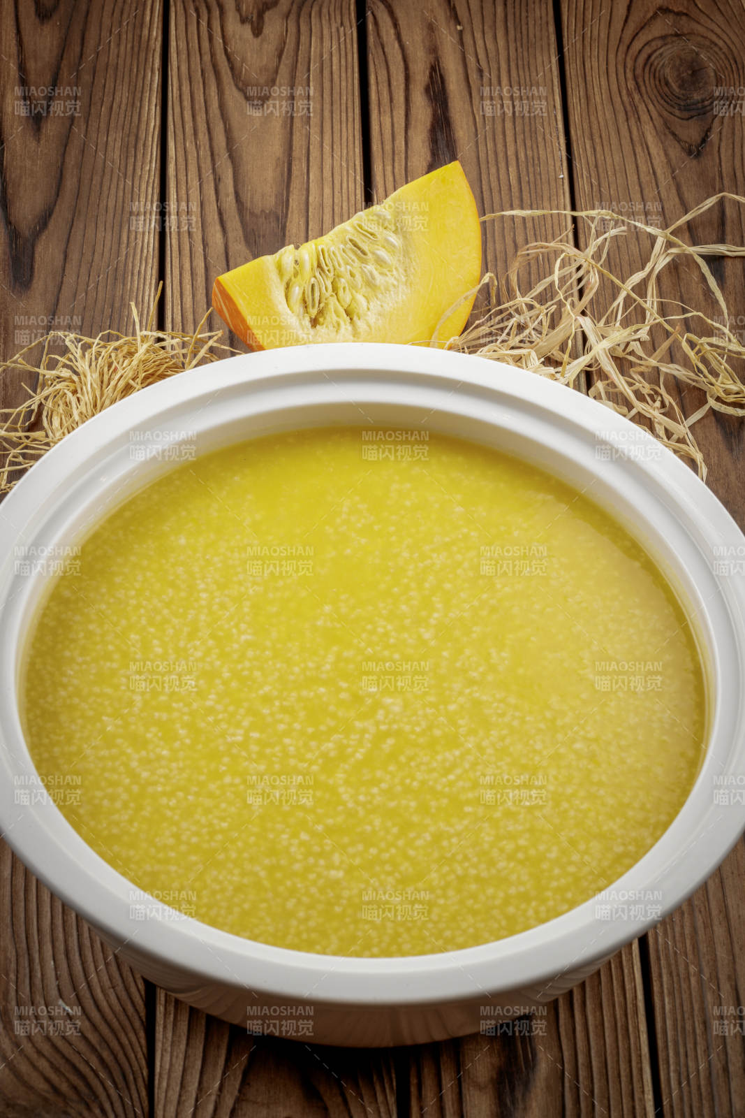 白色汤盆装的金瓜小米粥图片