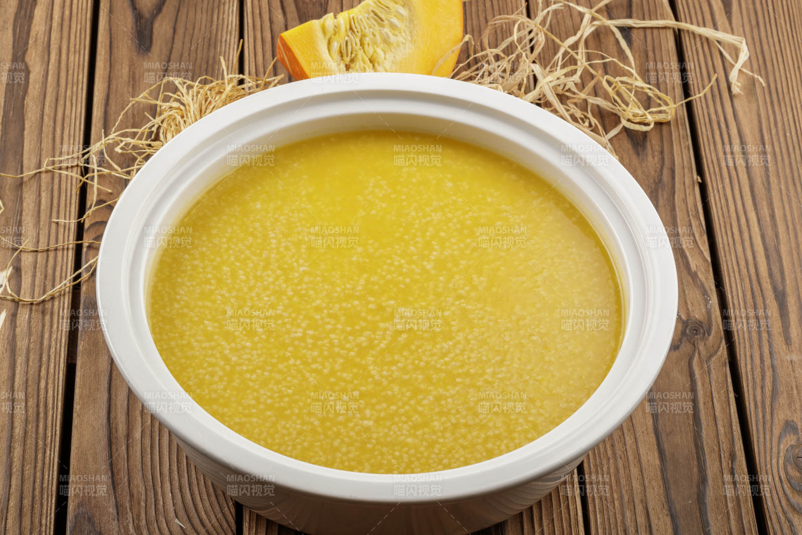 白色汤盆装的金瓜小米粥图片