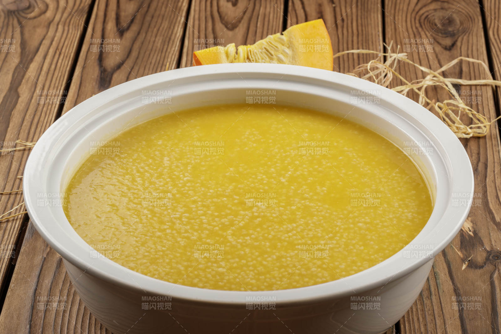 白色汤盆装的金瓜小米粥图片
