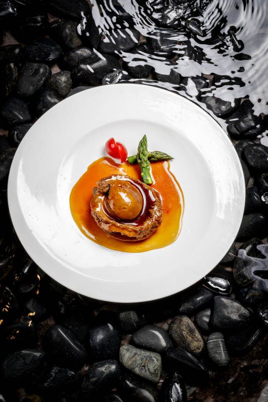 白色瓷盘装的浇汁南非干鲍图片