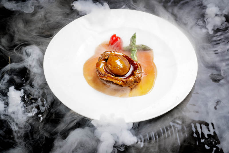 白色瓷盘装的浇汁南非干鲍图片