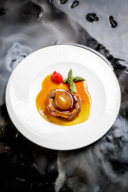 白色瓷盘装的浇汁南非干鲍图片