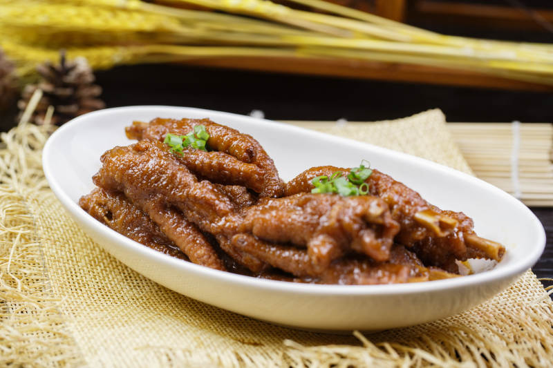 白色瓷盘装的照烧鸡爪图片