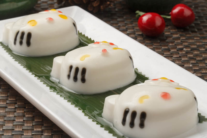 KT猫造型的糯米糕摆放在餐垫上图片