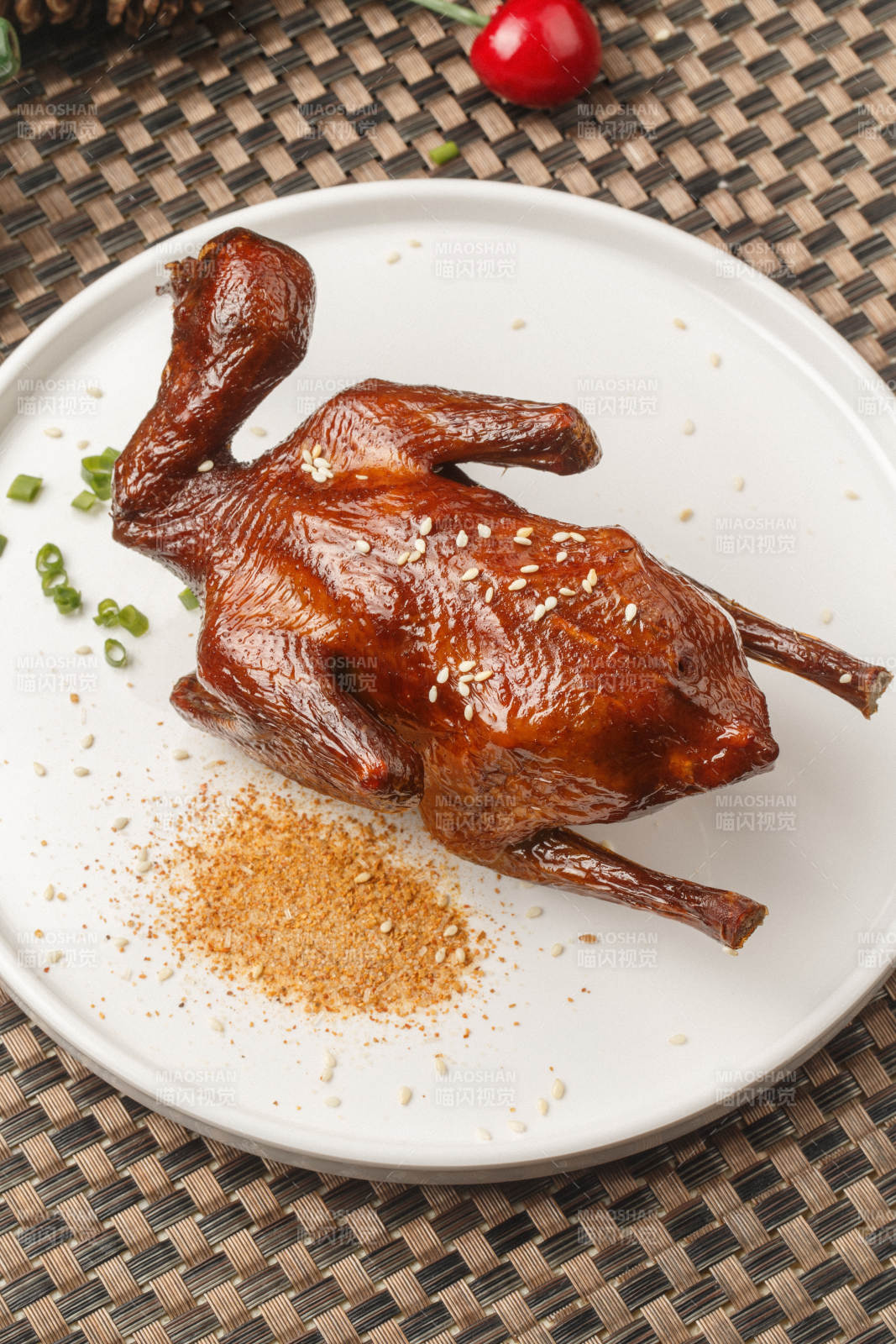 圆形白瓷盘装的港式脆皮乳鸽摆放在餐垫上图片