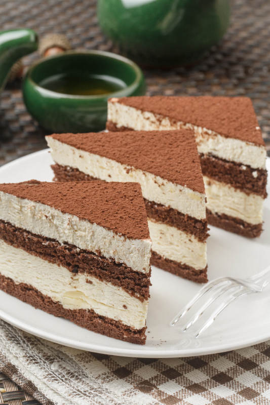 巧克力撒粉奶油慕斯摆放在餐布上图片