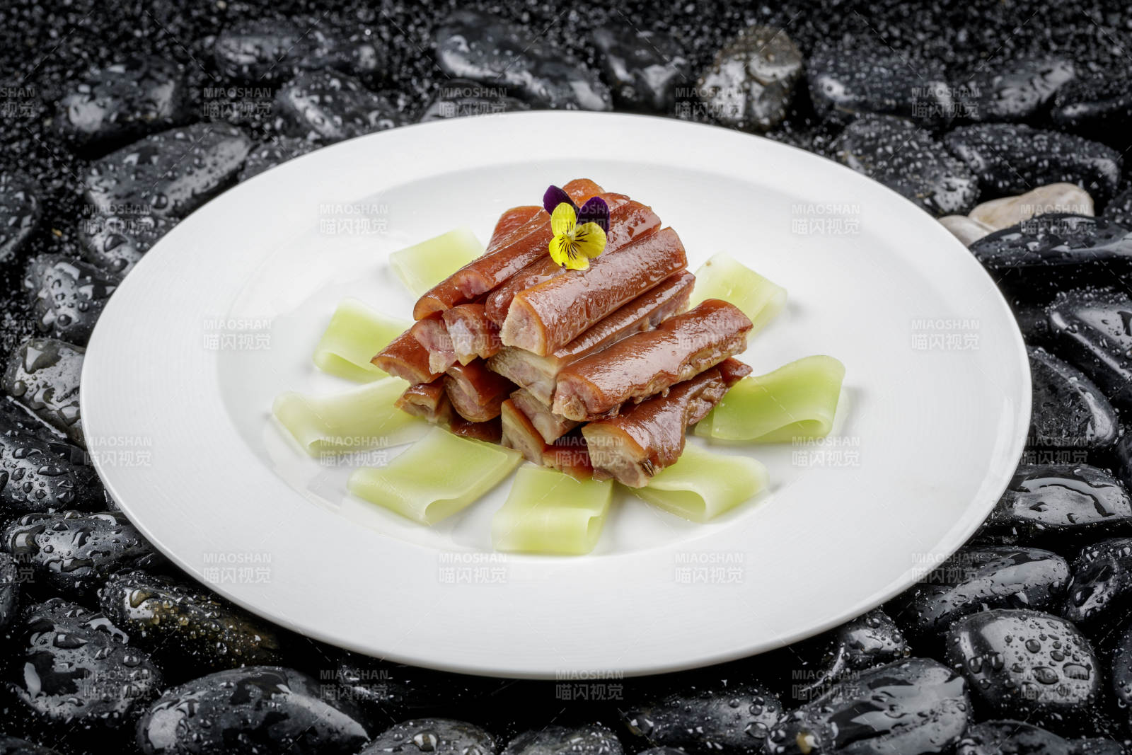 馋嘴猪尾摆放在黑色鹅卵石上图片