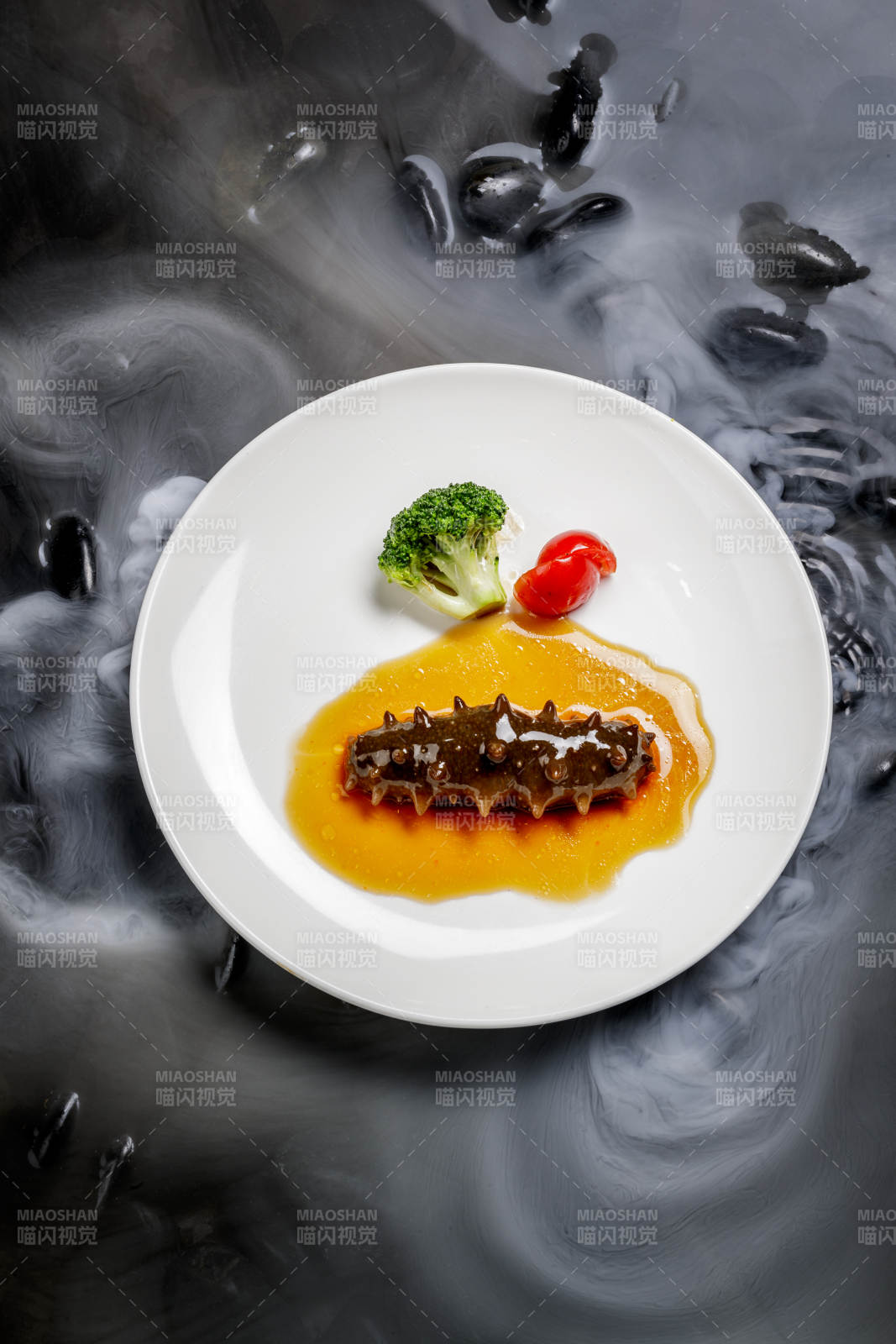 鲍汁扣辽参摆放在干冰缭绕的水中图片