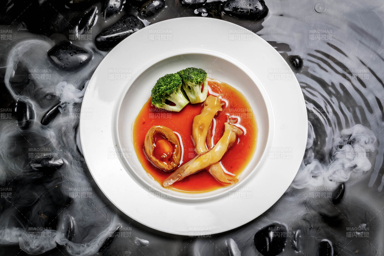 鲍汁鲍鱼烩花胶摆放在干冰缭绕的水中图片