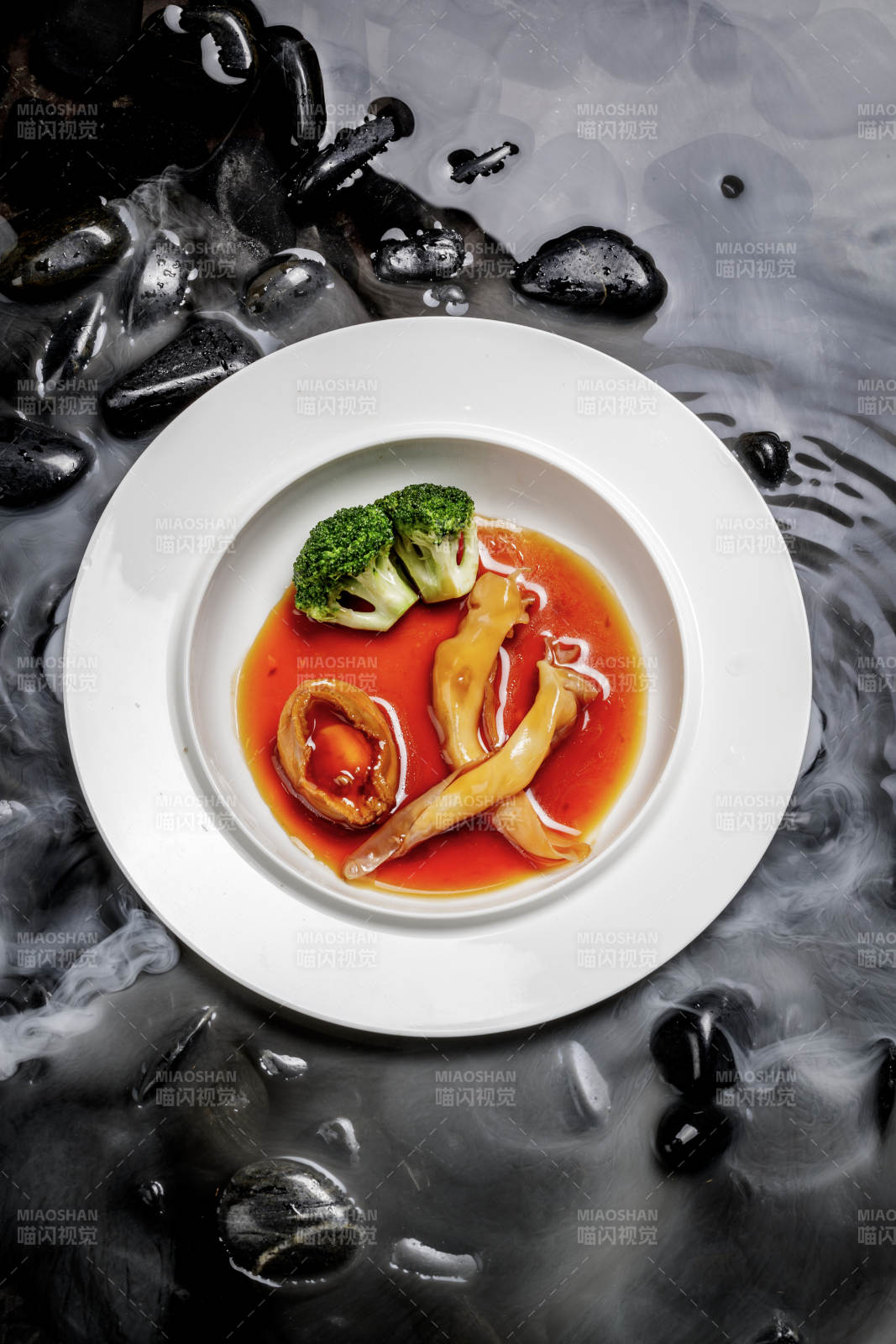 鲍汁鲍鱼烩花胶摆放在干冰缭绕的水中图片