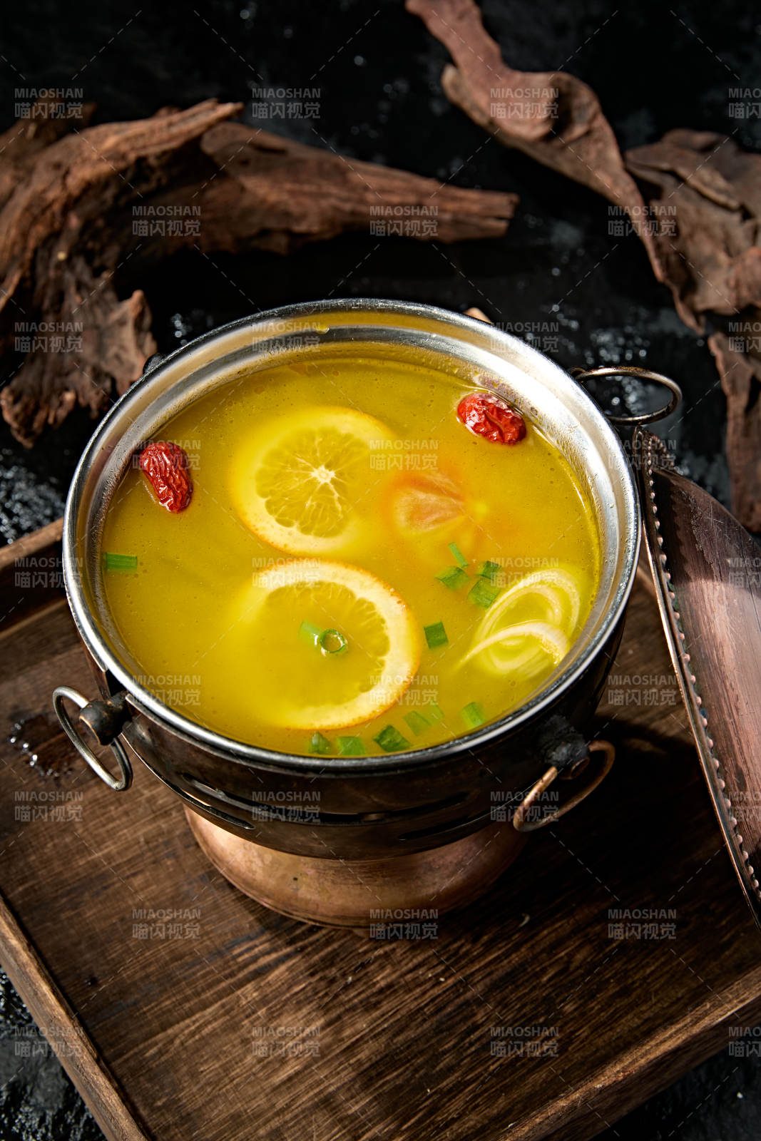 精致小火锅装的橙味鸡汤锅底图片