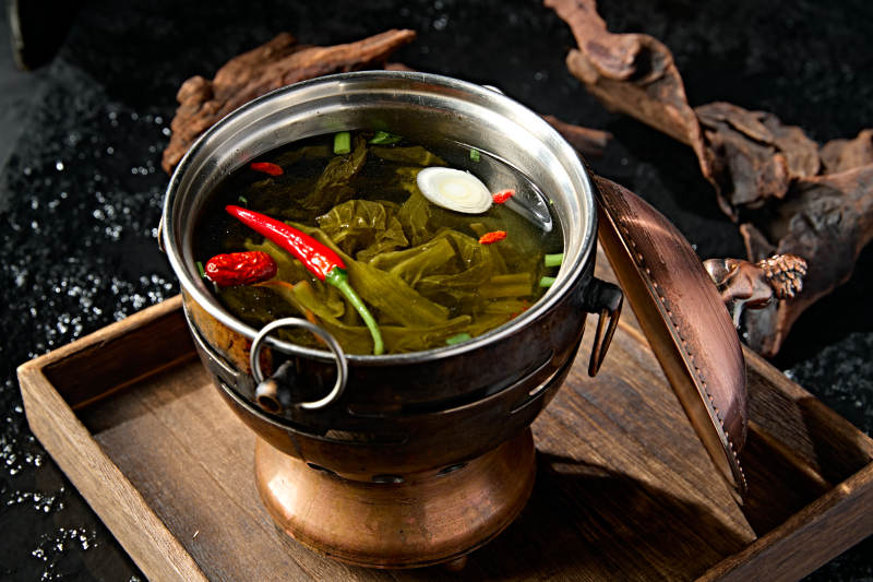 精致小火锅装的酸菜汤锅底图片