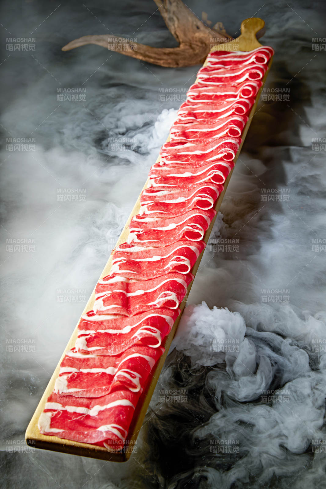 干冰缭绕的背景上摆放的和牛一米肉片图片