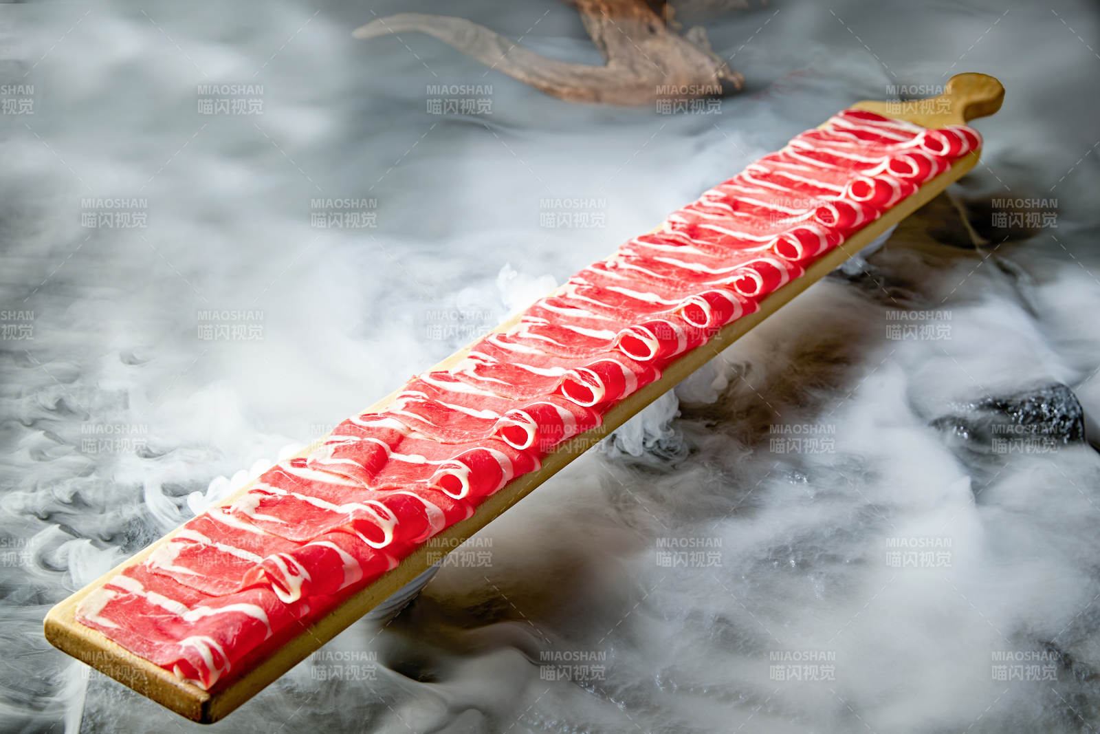干冰缭绕的背景上摆放的和牛一米肉片图片