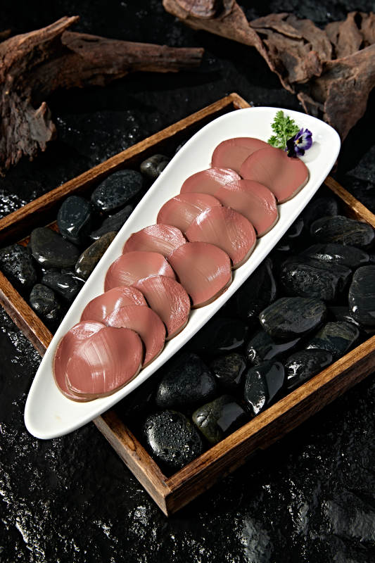 白色瓷盘装的火锅食材鸭血切片图片