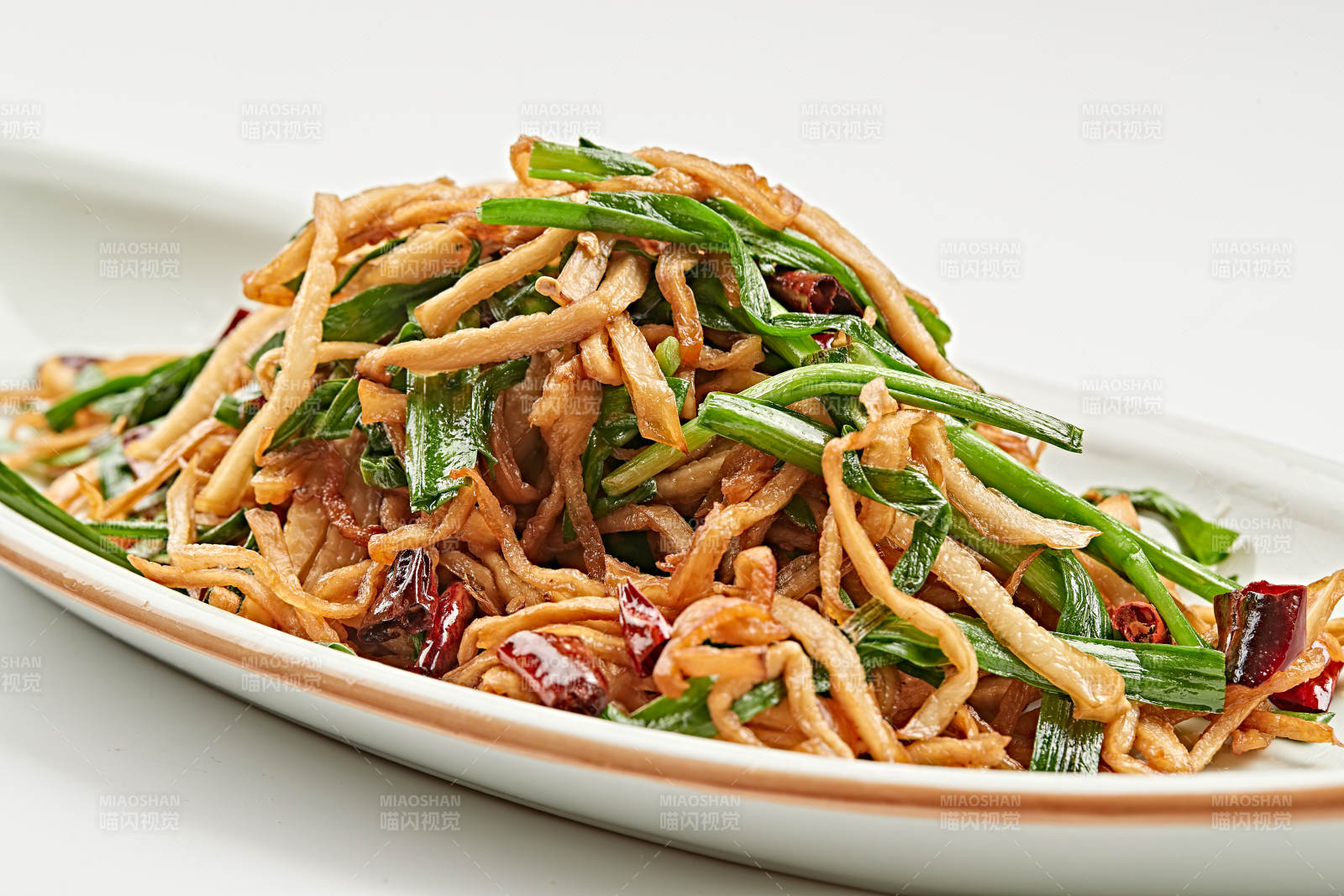 白色瓷盘装的韭菜辣炒杏鲍菇图片