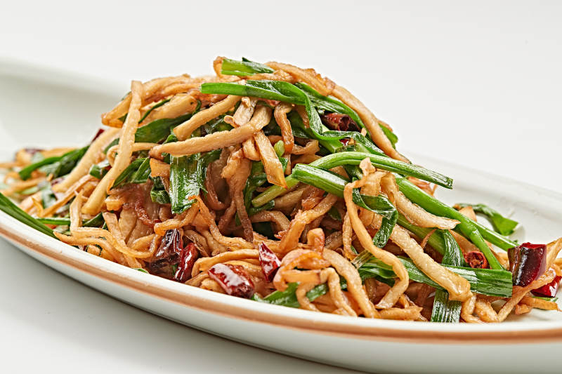 白色瓷盘装的韭菜辣炒杏鲍菇图片