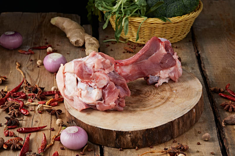 白色背景下的生鲜猪棒骨图片